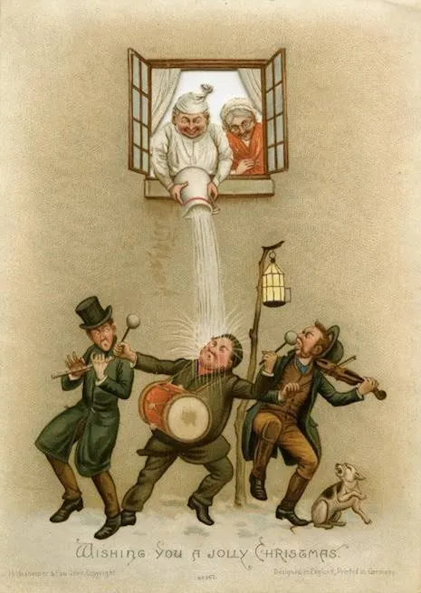 A Victorian Christmas card: a man in a nightcap empties a jug from an upstairs window onto three street musicians playing a drum, flute and fiddle below, with a dog barking; captioned Wishing you a jolly Christmas