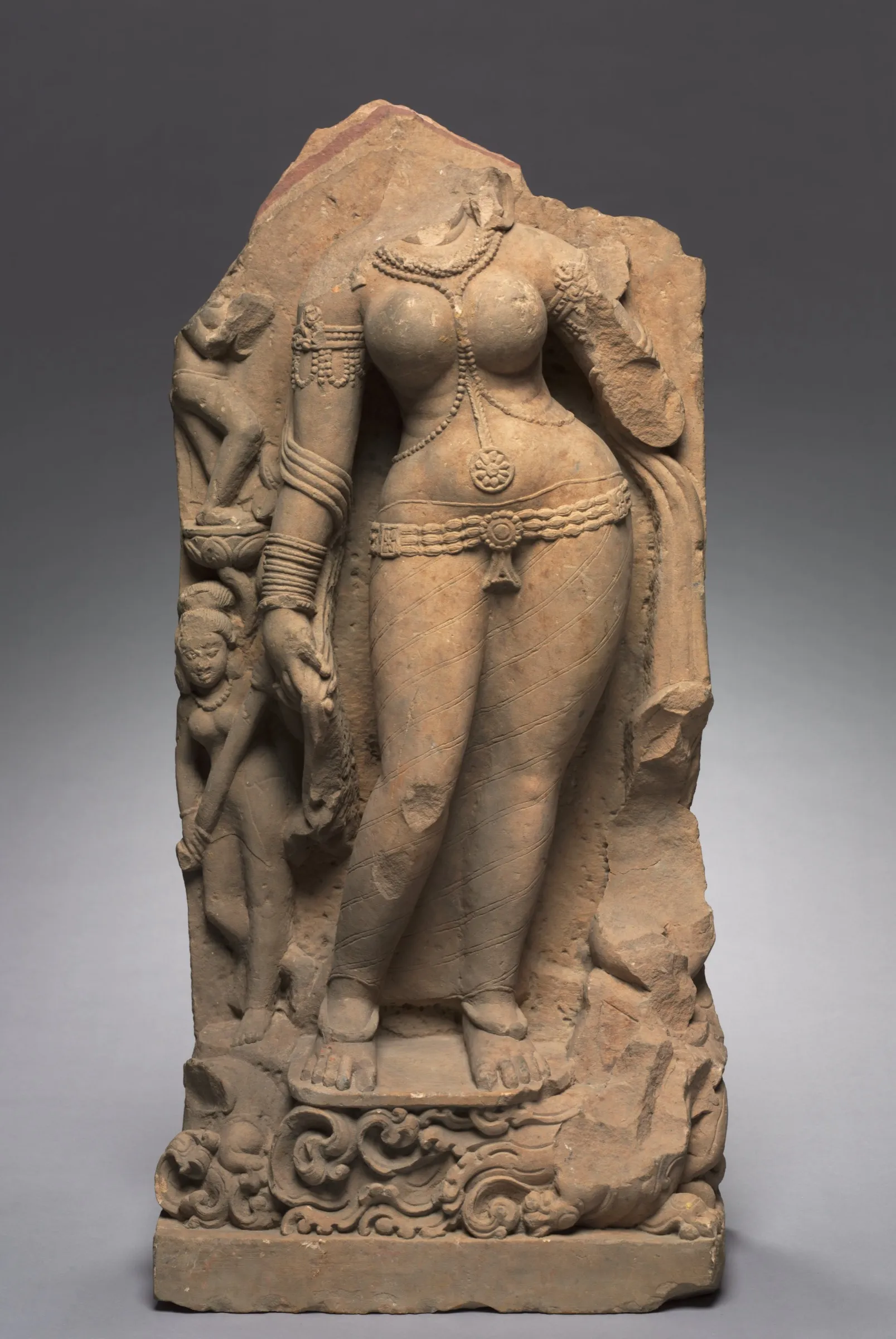 A carved stone relief of the river goddess Ganga, a graceful female figure standing with attendants