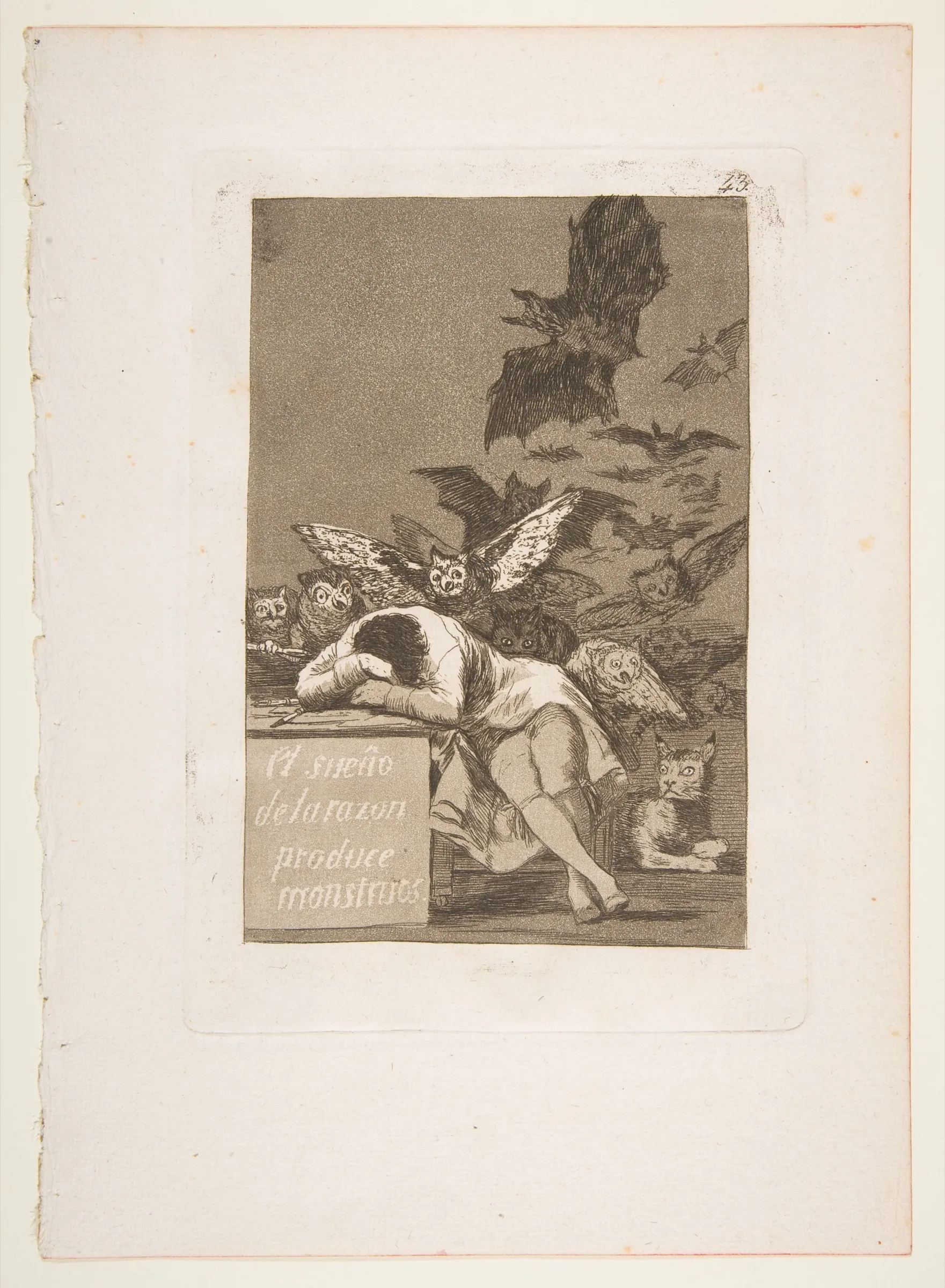 A man asleep at a desk with his head on his arms, while owls and bats crowd the dark behind him