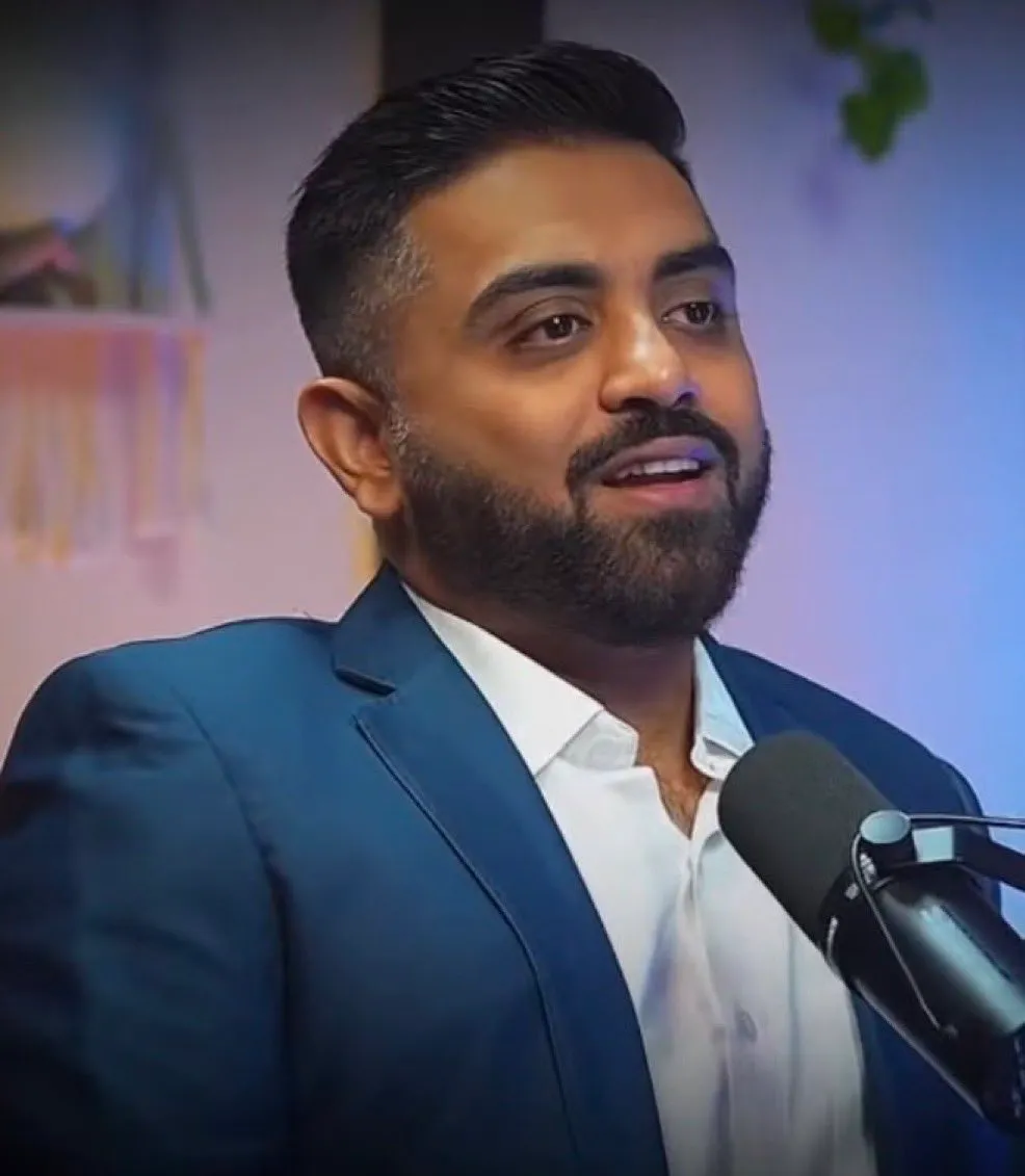 Smit Machchhar in a blue blazer and white shirt, speaking into a studio microphone